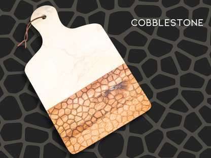 A marble and wooden charcuterie board engraved in the pattern "cobblestone". This is an organic pattern that resembles a cobblestone road with stones of different sizes and shapes