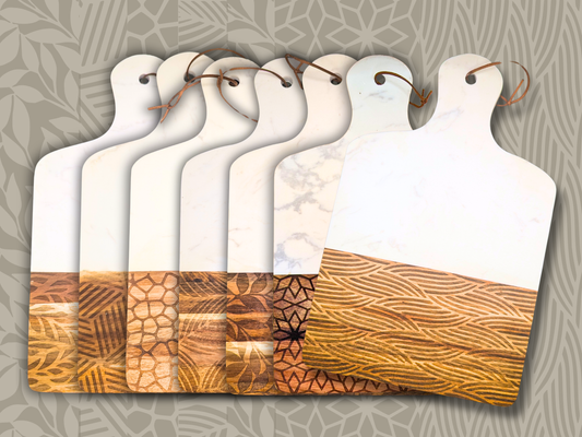 Seven wood and marble cutting boards in different patterns against a khaki colored background